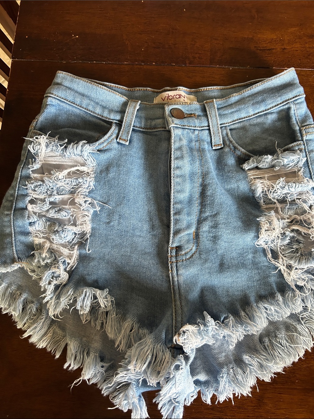 Vibrant light blue distressed denim shorts with frayed hem